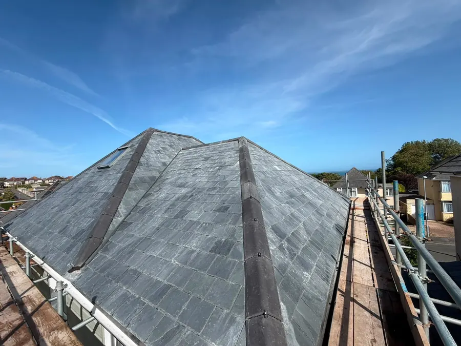 Finished slate hip roof under a blue sky, Dawn Roofs Ltd
