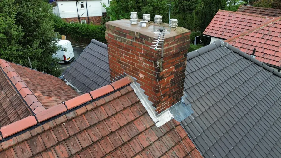 Slate slope meeting a red tile roof at the chimney, Dawn Roofs Ltd
