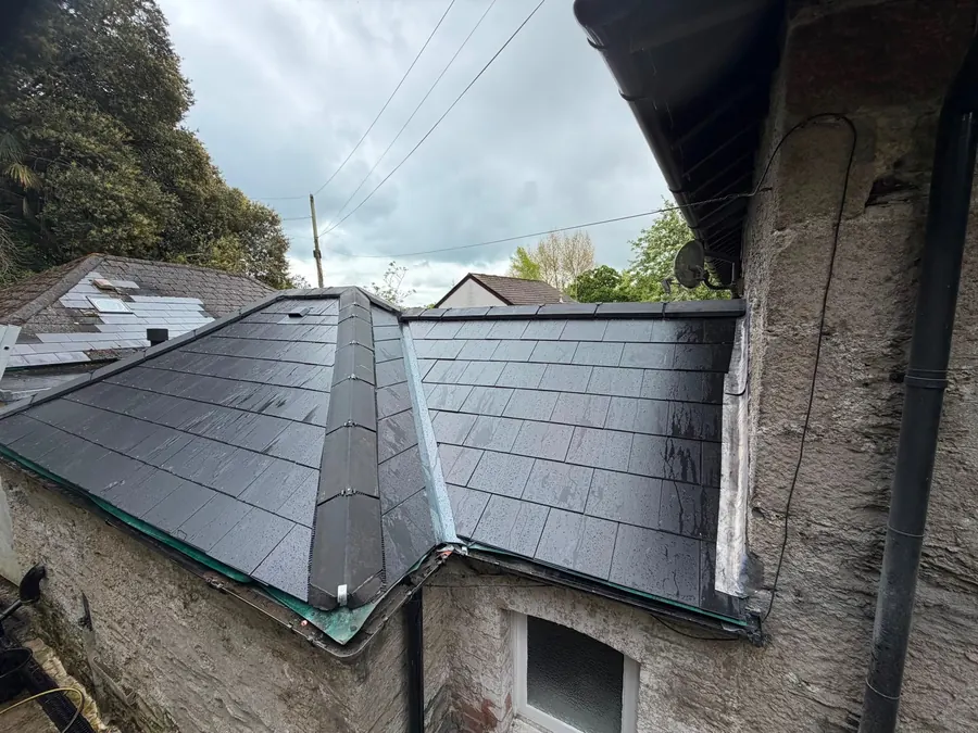 Slate valley against a stone wall, Dawn Roofs Ltd